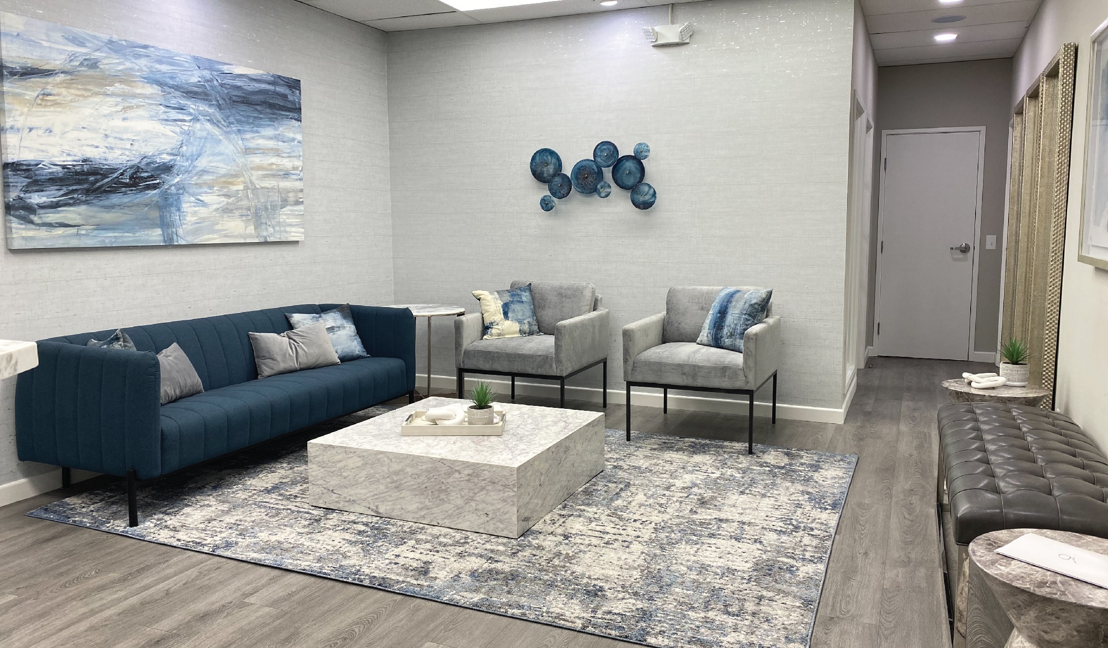 Modern lobby of the Advanced Institute for Plastic Surgery in Redlands, CA, featuring blue and grey tones for a sleek and welcoming atmosphere.