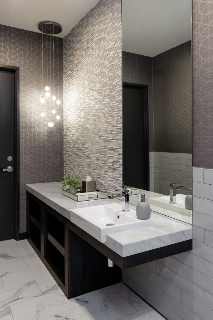 Sleek bathroom sink area in the Advanced Institute for Plastic Surgery Temecula office, featuring modern lighting hanging from the ceiling.